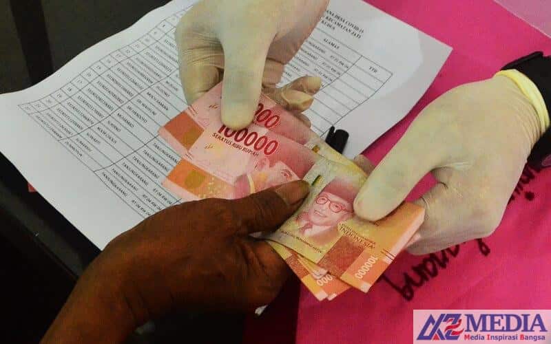 Warga menerima Bantuan Langsung Tunai Dana Desa (BLT-DD) di Balai Desa Tanjungkarang, Jati, Kudus, Jawa Tengah, Senin (18/5/2020). Pemerintah melalui Kementerian Desa, Pembangunan Daerah Tertinggal dan Transmigrasi memberikan BLT-DD sebesar Rp600 ribu per bulan per kepala keluara (KK) selama tiga bulan kepada 23.195 KK yang tersebar di willayah itu yang terdiri dari warga miskin, orang sakit kronis dan orang kehilangan pekerjaan akibat terdampak COVID-19. ANTARA FOTO/Yusuf Nugroho/wsj.